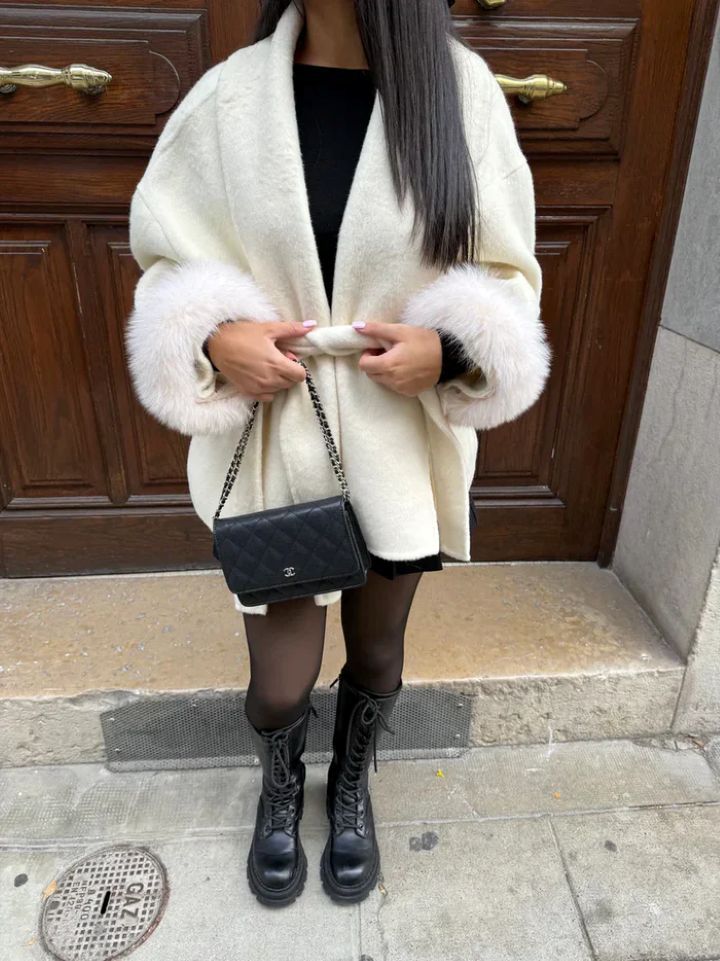 Cremefarbener Oversize-Mantel mit Fellärmeln, kombiniert mit schwarzen Stiefeln und Tasche, IsabellBoutique030