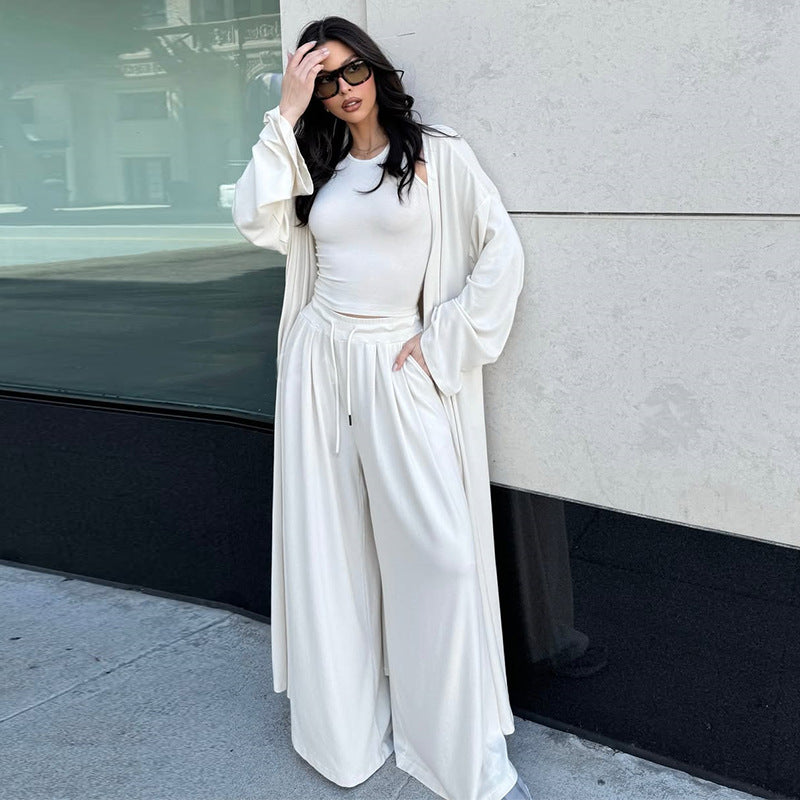 Das Ensemble besteht aus einem figurbetonten Top, einer locker fallenden Wide-Leg-Hose und einem passenden Cardigan für den kompletten Look.