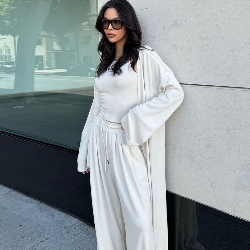 Das Ensemble besteht aus einem figurbetonten Top, einer locker fallenden Wide-Leg-Hose und einem passenden Cardigan für den kompletten Look.