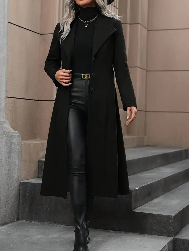 Schwarzer Längenmantel mit Reverskragen, kombiniert mit schwarzer Rollkragenpullover, Lederhose und Stiefeln. IsabellBoutique030