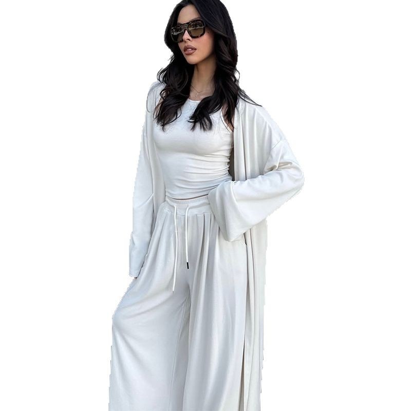 Das Ensemble besteht aus einem figurbetonten Top, einer locker fallenden Wide-Leg-Hose und einem passenden Cardigan für den kompletten Look.