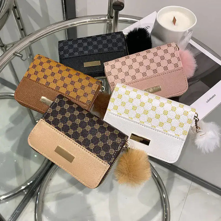 Modische Damen Geldbörsen in Beige, Schwarz, Braun, Weiß und Rosa mit Muster-Design, Reißverschluss und Bommel-Anhänger, elegant auf dem Tisch arrangiert, IsabellBoutique030.